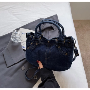 Dettaglio texture della borsa tote in denim blu scuro con tasche vintage e rivetti