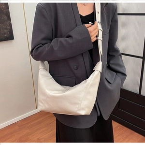 Macro detail of creamy hobo bag showing high-quality leather texture and fine stitching