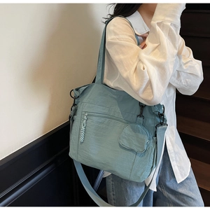 Detail view of Morandi blue nylon tote bag with detachable pouch and adjustable strap