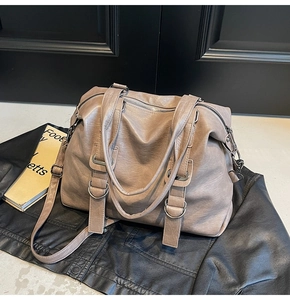 Macro detail of khaki faux leather tote bag with pleats and silver metal hardware