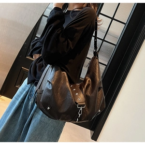 Detailed view of dark brown soft leather hobo bag with silver star rivets and strap hooks