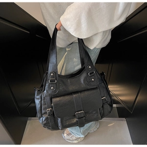 Close-up of black retro textured tote bag with large front flap pocket and sturdy handles