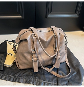 Close-up of vintage brown tote bag with natural leather texture and metal stud details