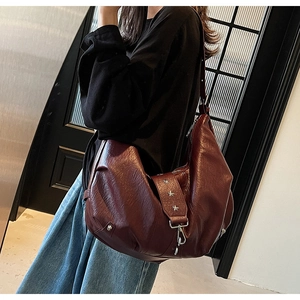 Detail of burgundy tote bag showing glossy pleated leather and star rivet studs