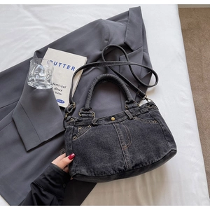 Dettaglio della borsa tote in denim grigio vintage con borchie in metallo e tracolla