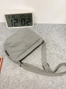 Sac bandoulière gris clair minimaliste avec sangle réglable et tissu en nylon texturé