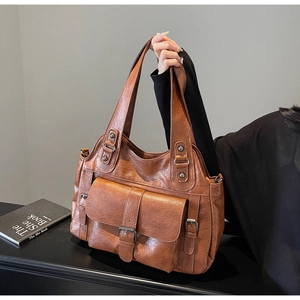 Detail of caramel brown PU leather tote bag with front pocket and metal rivets