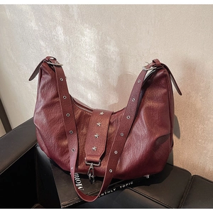 Detail view of burgundy tote bag with silver star studs and vintage leather texture
