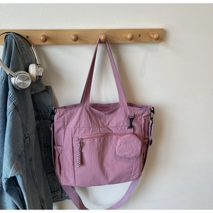 Detail of mauve nylon tote bag with small round coin purse and zipper exterior pocket