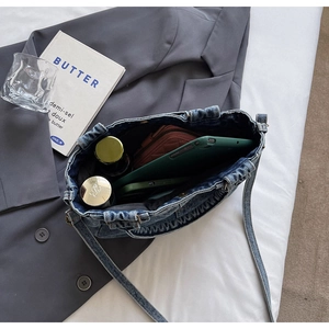Dettaglio della borsa tote in denim che mostra l'ampio spazio interno e il tessuto lavato