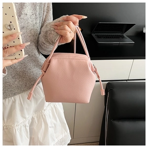Close-up detail of pink lychee textured leather on a pleated shell handbag for women
