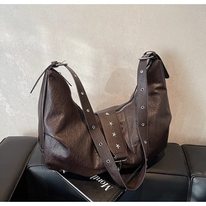 Close-up of vintage brown tote bag with star rivets and silver metal eyelets details