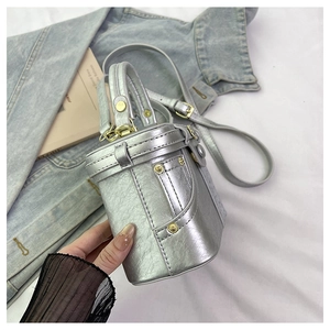 Detailed view of silver metallic bucket bag featuring rivet accents and adjustable strap