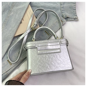 Close-up of silver metallic leather handbag with wrinkled texture and stylish top handle