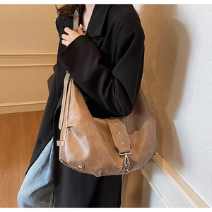 Detail of vintage textured hobo bag with silver star rivets and soft leather finish