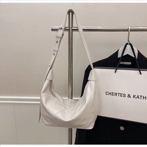 Detail of cream hobo bag showing fine leather texture and adjustable silver buckle