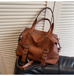 Detail view of caramel brown faux leather tote with metallic rings and adjustable strap