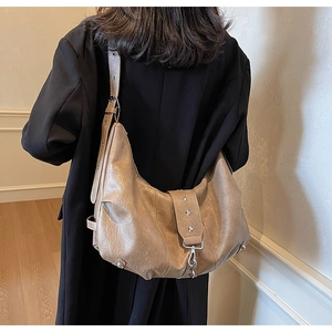 Detail of soft beige hobo bag featuring vintage texture and silver star rivet accents