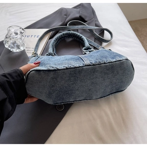 Dettaglio della borsa tote in denim vintage con manici imbottiti e tracolla regolabile