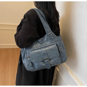 Detail view of a vintage blue soft leather tote bag with buckles and magnetic pocket