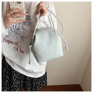 Detail of light green drawstring shell bag with premium lychee grain leather texture
