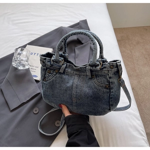 Dettaglio della borsa tote in denim lavato vintage con tasche retrò e borchie in metallo
