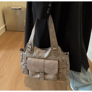 Detailed close-up of retro khaki brown PU leather handbag with vintage buckle pockets