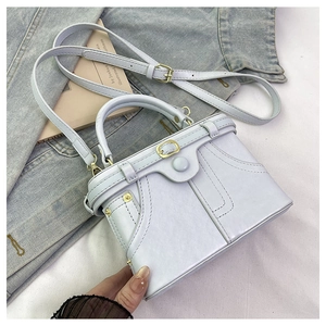 Detail of white mini box bag with faux denim stitching and gold metallic buckle