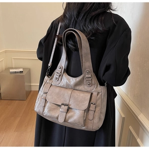 Detailed macro view of retro wrinkled leather tote bag with silver metallic buckle detail
