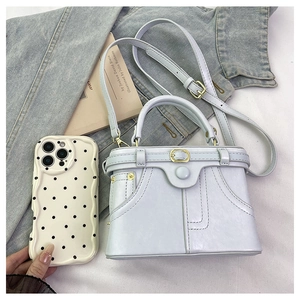 Detailed close-up of retro denim style mini box bag with gold hardware and stitch details
