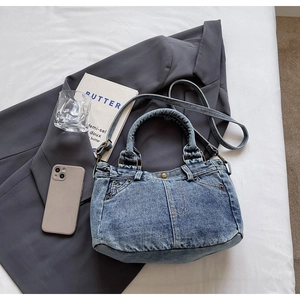 Dettaglio della borsa tote in denim lavato vintage con tasca funzionale e manici solidi