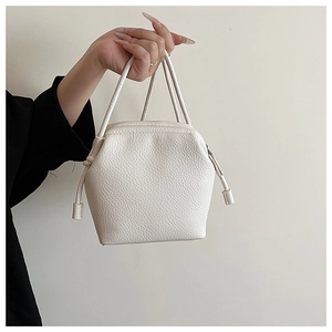 Detail showing white lychee texture leather handbag with unique hexagonal side panels