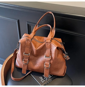 Detail of brown litchi pattern leather Boston tote bag with adjustable shoulder strap
