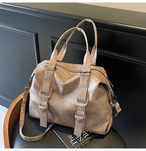 Detail of taupe faux leather tote bag with metal ring hardware and adjustable shoulder strap