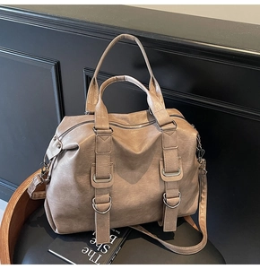 Close-up of vintage brown leather texture and metal buckle on large tote bag