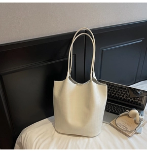 Λεπτομέρεια macro της off-white τσάντας tote από δέρμα με ανάγλυφο σχέδιο κροκόδειλου