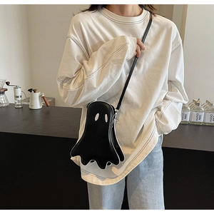Détail d'un mini sac bandoulière en forme de fantôme en similicuir noir mat sur un modèle