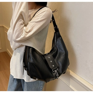 Detail of black crescent shoulder bag with silver star studs and textured leather