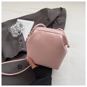 Close-up of pink lychee leather crossbody bag featuring unique geometric hexagon shape