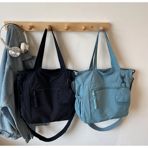 Detail of nylon tote bag with front zipper pocket and round coin purse accessory
