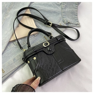 Detail of vintage denim style black box bag with retro pocket design and rivet accents