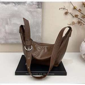 Detail view of deep brown leather hobo bag with adjustable silver metal buckle strap