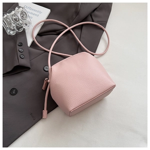Detail of light pink lychee texture leather shell bag with elegant minimalist strap