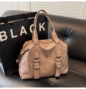 Macro shot of brown retro tote bag with dual handles and metal D-ring details