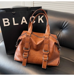 Detailed close-up of brown vintage PU leather tote bag with vertical strap and metal D-ring