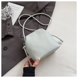 Detail of mint green lychee grain leather texture on elegant shoulder bag