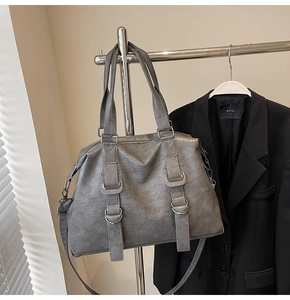 Detail of grey tote bag with soft leather texture, metal ring buckle and detachable strap