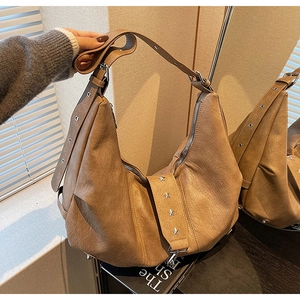 Detail of soft leather hobo bag featuring silver star rivets and eyelet strap