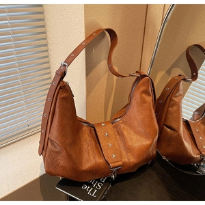 Close-up of vintage brown leather hobo bag with silver star metallic ornaments