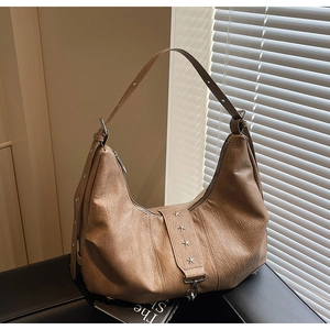 Detailed macro view of retro brown leather bag with silver star studs and texture